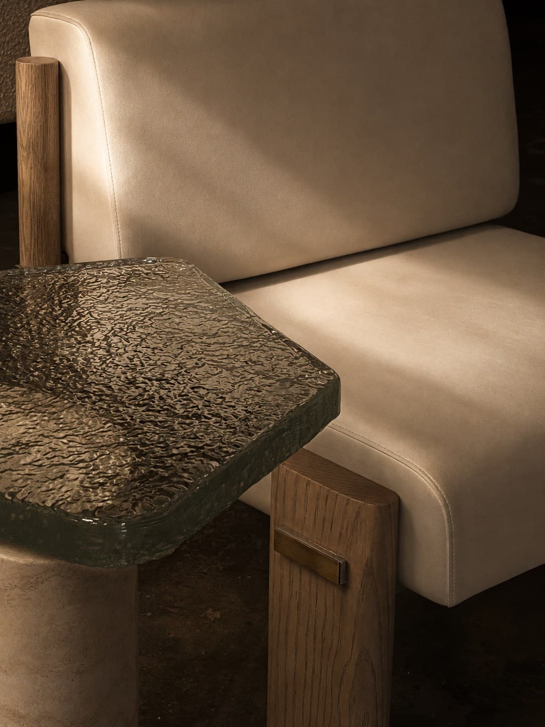 A leather lounge chair beside a cast glass side table